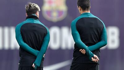 Barcelona’s Lionel Messi chats with Luis Suarez during training. Lluis Gene / AFP
