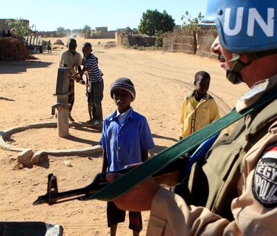 File photo: Children stand near an Egyptian United Nations-African Union Mission in Darfur (UNAMID) soldier standing guard in Al Fashir, northern Darfur, Sudan. AFP