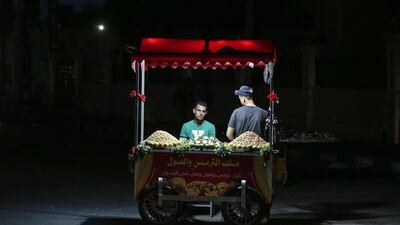 Palestinian vendors wait for customers behind their stall in Gaza City. AFP