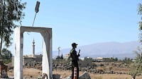 A member of Syria's security forces stands guard outside a former army base near the city of Quneitra. AFP