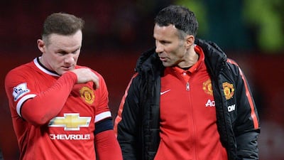 Manchester United's Wayne Rooney leaves the pitch with assistant coach Ryan Giggs at the end of their FA Cup loss to Arsenal on Monday. Oli Scarff / AFP / March 9, 2015