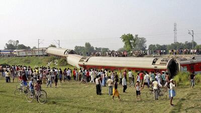People gather around a passenger train that derailed in Bihar, India. AP Photo