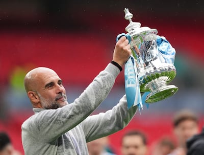 Pep Guardiola holds the FA Cup following Manchester City's win over Chelsea at Wembley last Saturday. PA