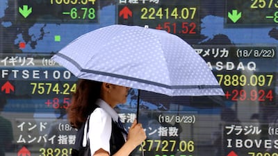 A woman walks by an electronic stock board of a securities firm in Tokyo. Japanese retail investors are exposed to double-deckers - funds that purchase high-yield debt. Photo: AP