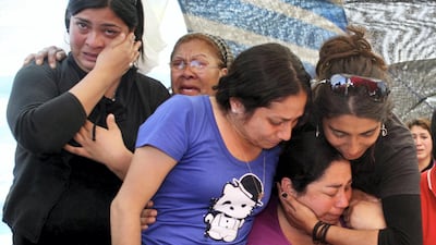 Relatives of trapped miners react after learning that the 33 miners were found alive in Copiapo, August 22, 2010. The thirty-three Chilean miners trapped deep underground sent a message to the surface tied to a drill on Sunday, saying they were all alive in their first contact since a cave-in 17 days ago, but experts said it would take months to dig them out. REUTERS