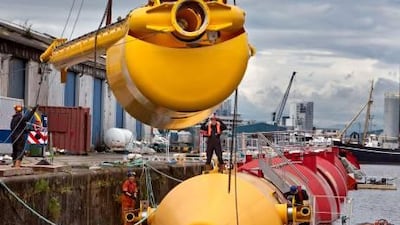 Employees work on a section of the Pelamis P2 Wave Energy Convertor, manufactured by Pelamis Wave Power Ltd, as it sits in the water at Leith docks in Edinburgh, Scotland.