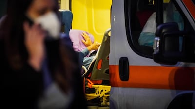 Health workers wait with a patient in a queue of Ambulances outside the San Leonardo Hospital in Naples. EPA