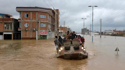 Military vehicles rescue people after flash flooding around the northern city of Aq Qala. AP Photo