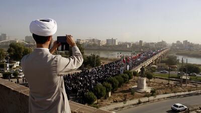 A clergyman takes a picture of a pro-government demonstration in the city of Ahvaz in south-western Iran on January 3, 2018. Mohammad Ahangari / ISNA via AP
