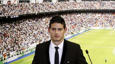Real Madrid's new signing, Colombian midfielder James Rodriguez, poses for the media with his new shirt during his presentation at Santiago Bernabeu stadium, in Madrid, Spain, on July 21, 2014. EPA / Kiko Huesca