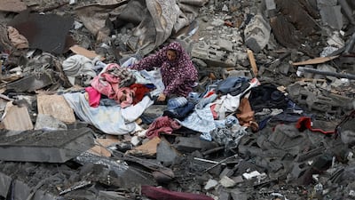 A Palestinian woman gathers her belongings after an Israeli air strike on central Gaza. Reuters