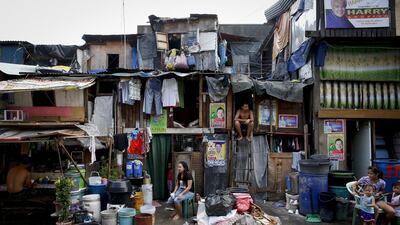 Residents of a slum in Navotas city sit outside their homes plastered with campaign posters of politicians running for election, as world leaders arrive in Manila for the 2015 Asia-Pacific Economic Cooperation (APEC) summit, east of Manila, Philippines. Diego Azubel / EPA