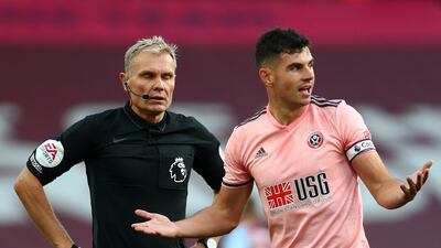 Sheffield United's Irish defender John Egan reacts in front of referee Graham Scott after he fouled Aston Villa's English striker Ollie Watkins (not seen) leading to a straight red card. AFP
