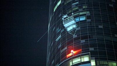 A witness said he believed there were two men in the cradle when strong winds caused it to veer wildly and crash into windows of the high-rise Sun Tower - but neither was injured.