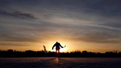 A hockey player takes to the ice at sunrise for the U.S. Pond Hockey Championships on Lake Nokomis in Minneapolis, Minnesota. Kevin Lamarque / Reuters