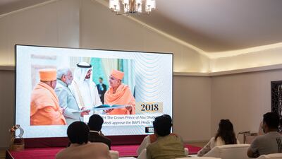 Volunteers and worshippers watch a video to know more about the progress of the temple.