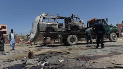Damaged vehicles are removed from the scene of a suicide bomb attack claimed by the Taliban in the Afghan district of Paghman in Kabul on May 25, 2016, which killed at least 11 people. Shah Marai/AFP