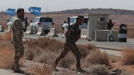 A convoy of UN vehicles passes a Syrian government checkpoint on its way to Sweida. AP