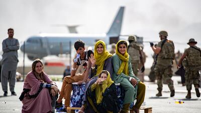 Displaced children wait for the next flight at Hamid Karzai International Airport, Kabul on August 19, 2021. AFP