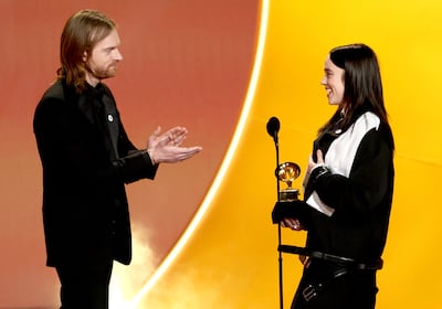 Billie Eilish, right, and Finneas celebrate their Song Of the Year award for Wildflower. AFP