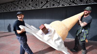 Visual artists carry an oversized sculpture of an ice cream outside the conference. AFP