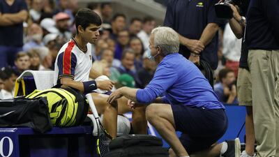 Carlos Alcaraz of Spain talks with a trainer during his quarter-finals match against Felix Auger-Aliassime of Canada before retiring hurt. Getty