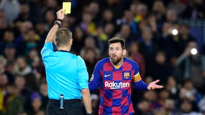 Barcelona's Lionel Messi is shown a yellow card for diving by French referee Clement Turpin. AFP