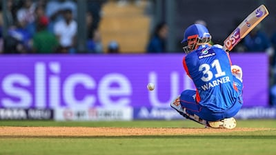 Delhi Capitals' David Warner falls down while playing a shot. He made 10 runs of eight balls before he was caught by Hardik Pandya off the bowling of Romario Shepherd. AFP