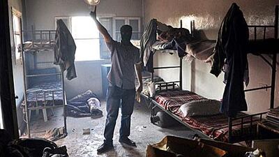 A masked opposition fighter poses inside the Shaar district police station in Aleppo yesterday.