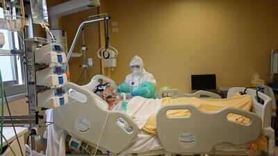 A health worker wearing protective gear takes care of a patient at the level intensive care unit, treating Covid-19 patients, at the San Filippo Neri hospital in Rome AFP