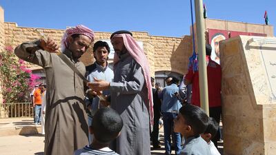 A Jordanian Bedouin winner checks ona sword he received as a prize during the camels race using robotic jockeys in the desert of Wadi Rum valley, south of Jordan.