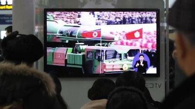 People watch a TV file footage of a North Korean rocket carried during a military parade, at Seoul Railway Station, South Korea.
