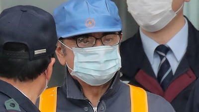 Former Nissan chairman Carlos Ghosn (C) is escorted as he walks out of the Tokyo Detention House. AFP