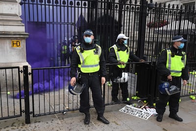 A smoke canister goes off during an anti-lockdown demonstration outside Downing Street in London, on Saturday. AFP