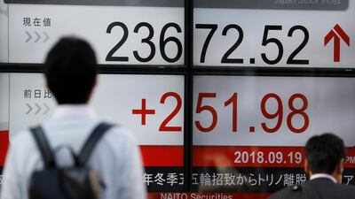 Pedestrians walk past a display of Tokyo's stock benchmark Nikkei Stock Average in Tokyo, Japan. The Nikkei recorded a 27-year peak on Friday. EPA/KIMIMASA MAYAMA