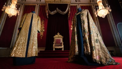 The Supertunica, left, and the Imperial Mantle on display in the throne room at Buckingham Palace