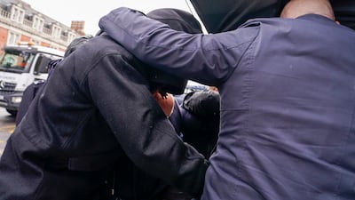 Kurt Zouma is hidden from photographers underneath umbrellas by security men as he arrives in court. PA