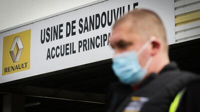 A worker wears a facemask at the entrance to a Renault factory in Sandouville, near Le Havre. The company is set to announce a restructuring this week, leading to speculation about potential plant closures. A spokesman for the CFDT Union said he was "not worried about French plants”. AFP