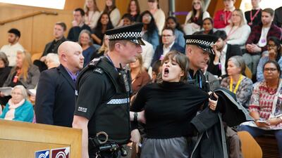 Police and security officers were forced to remove protesters from the Scottish Parliament in Edinburgh on Thursday, as Humza Yousaf led First Minister's Questions. AP