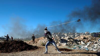 A Palestinian uses a sling to hurl stones during clashes with Israeli troops near the Jewish settlement of Beit El, near Ramallah. Reuters