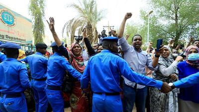 Sudanese police officers control civilians as they chant slogans outside the court during the new trial against ousted President Omar al-Bashir and some of his former allies on charges of leading a military coup that brought the autocrat to power in 1989 in Khartoum. Reuters