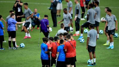 Young Liverpool fans get autographs from Mohamed Salah on the pitch during the training session at Besiktas Park, Istanbul. PA Wire