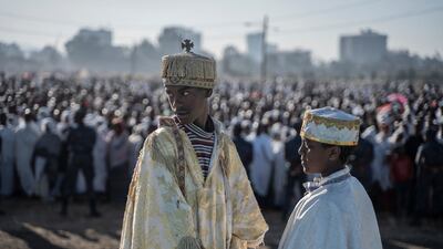 Two Ethiopian Orthodox deacons look on as worshippers gather to pray during the celebration of the Ethiopian Orthodox Epiphany in Addis Ababa. AFP