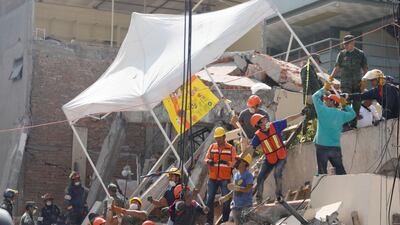 Rescue workers transport a tent as they search for students through the rubble at Enrique Rebsamen school. Edgard Garrido / Reuters