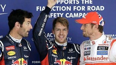 Red Bull driver Sebastian Vettel, centre, celebrates after taking pole position in qualifying for the Japanese Formula One Grand Prix, with teammate Mark Webber, left, who came in second and third placed McLaren driver Jenson Button, who qualified third but will start in eighth due to a grid penalty. Greg Baker / AP Photo