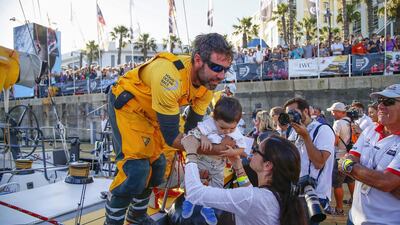 Abu Dhabi Ocean Racing navigator Simon Fisher, left, from Britain, greets his wife and daughter at the conclusion of the first leg of the 2014/15 Volvo Ocean Race on Wednesday in Cape Town. Nic Bothma / EPA