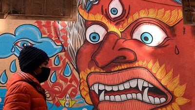 A resident wearing a protective face mask walks at the Patan Durbar Square area in Kathmandu. AFP