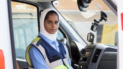 Maha Al Falasi, an EMT with the National Ambulance, sits in an ambulance at one of the centres in Ajman. Ruel Pableo for The National
