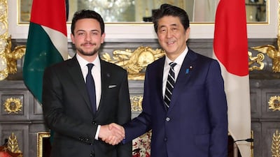 Japan's Prime Minister Shinzo Abe shakes hands with Crown Prince Hussein, the son of King Abdullah ll of Jordan, Tokyo. AFP