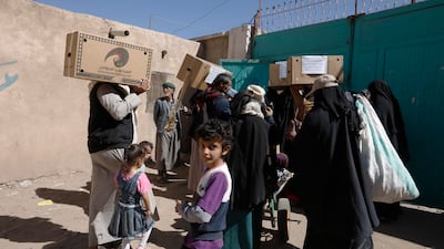 Yemenis carry boxes of food aid. EPA